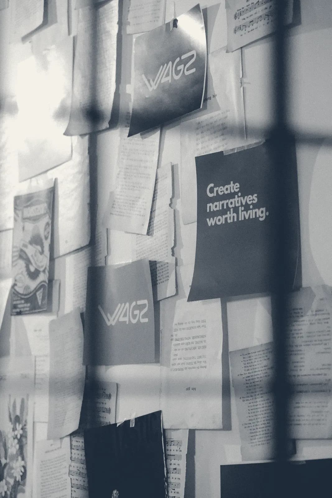 Góc tường dán kín trang viết, tấm biển ghi Create narratives worth living.